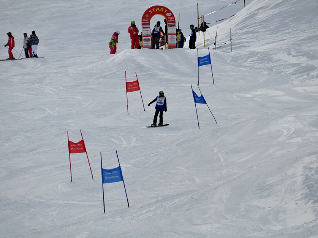 Blick auf die Rennstrecke mit rot-blauen Toren und Zielbogen.